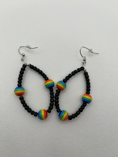 Black seed beads with rainbow beads throughout on earrings against a white background