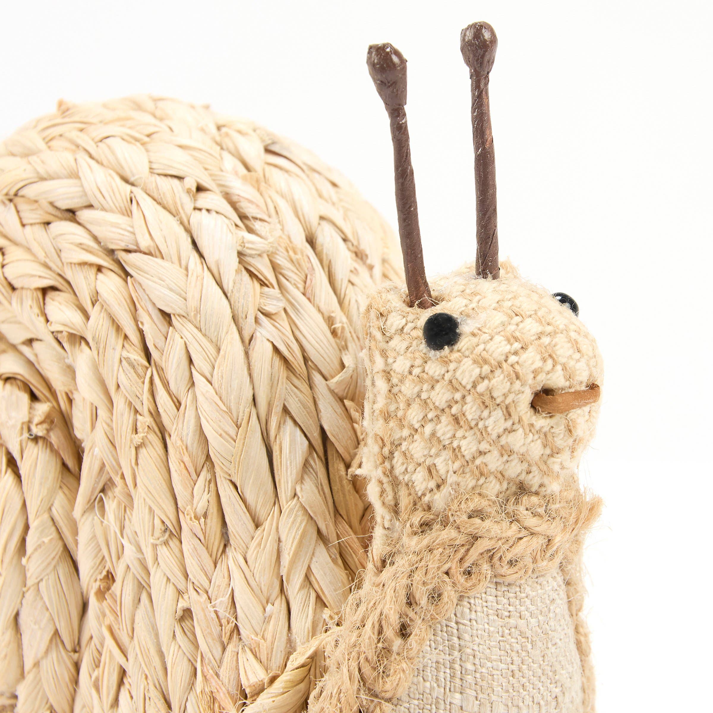 Woven snail sculpture with textured shell and antennae on a white background
