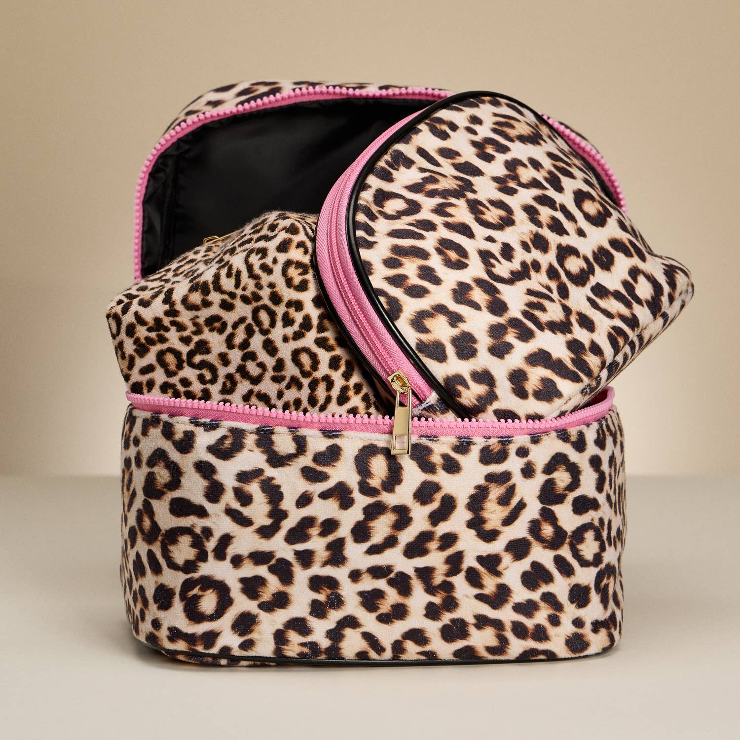 Leopard print makeup bag with pink zipper on a beige background