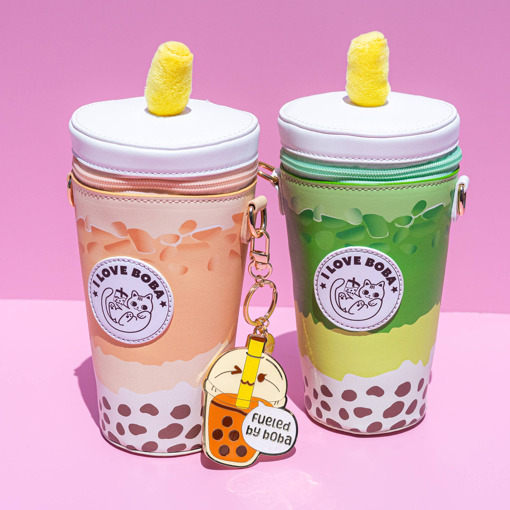 Two bubble tea-themed crossbody bags with a bubble tea keychain on a pink background