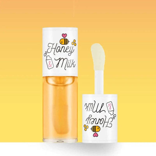 Yellow honey milk lip oil next to its applicator against a yellow background