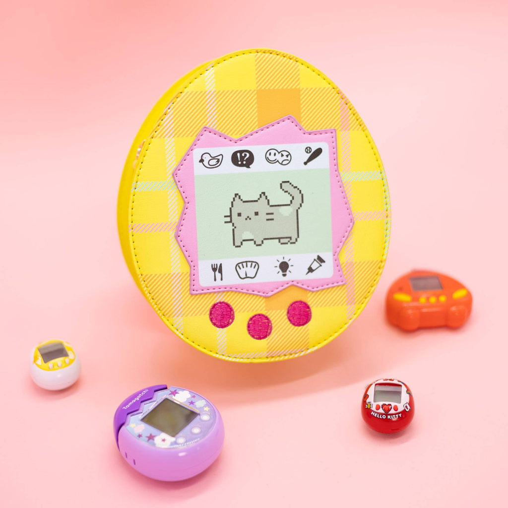 Yellow virtual pet crossbody bag with a cat on it with a pink background