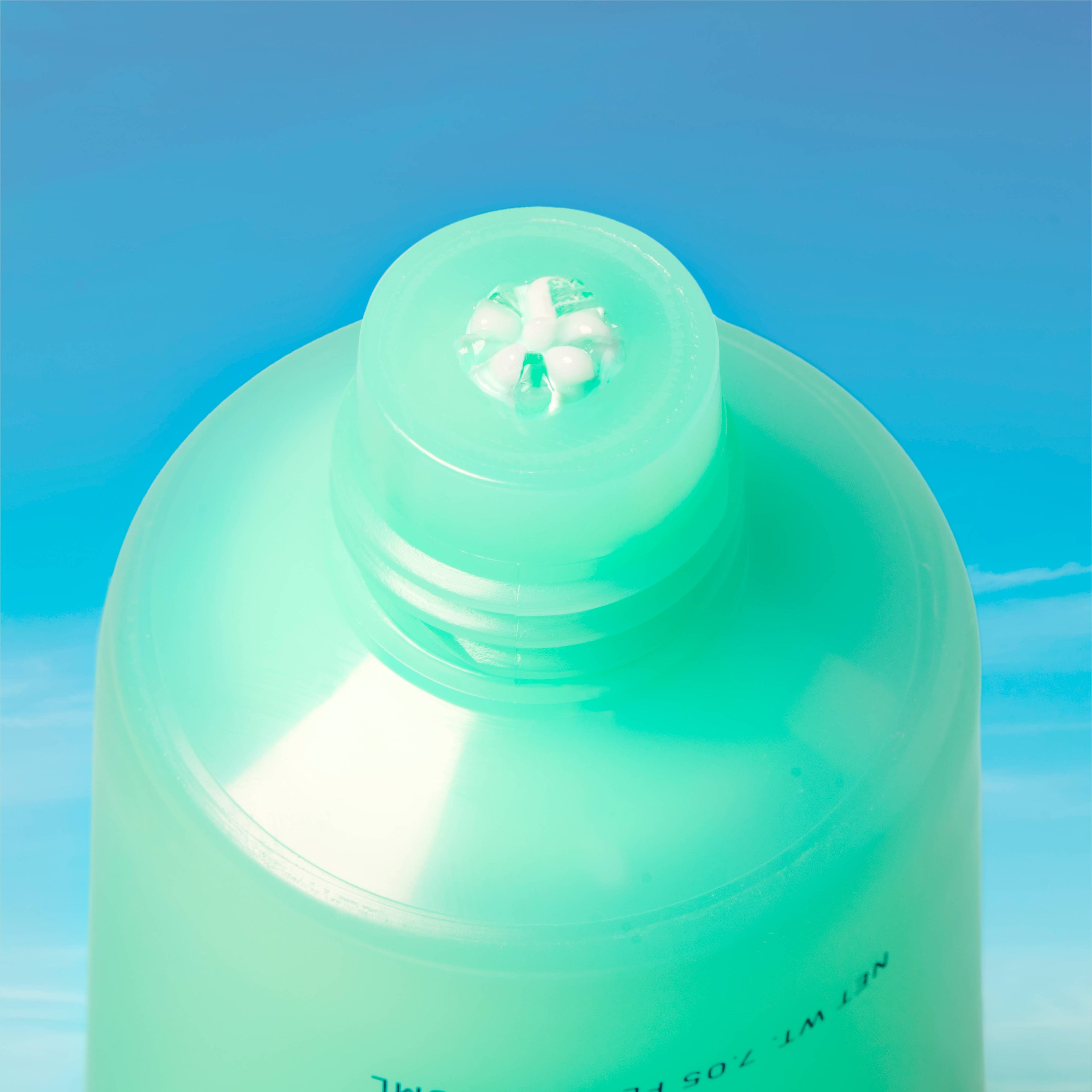 Green bottle cap on a blue gradient background