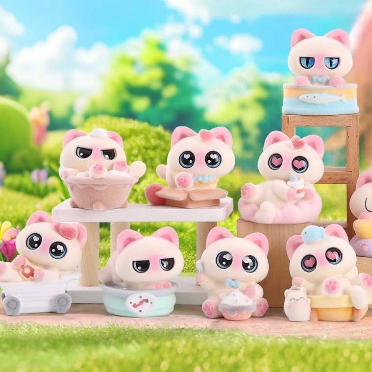 Collection of pink cat-themed figurines in a garden setting