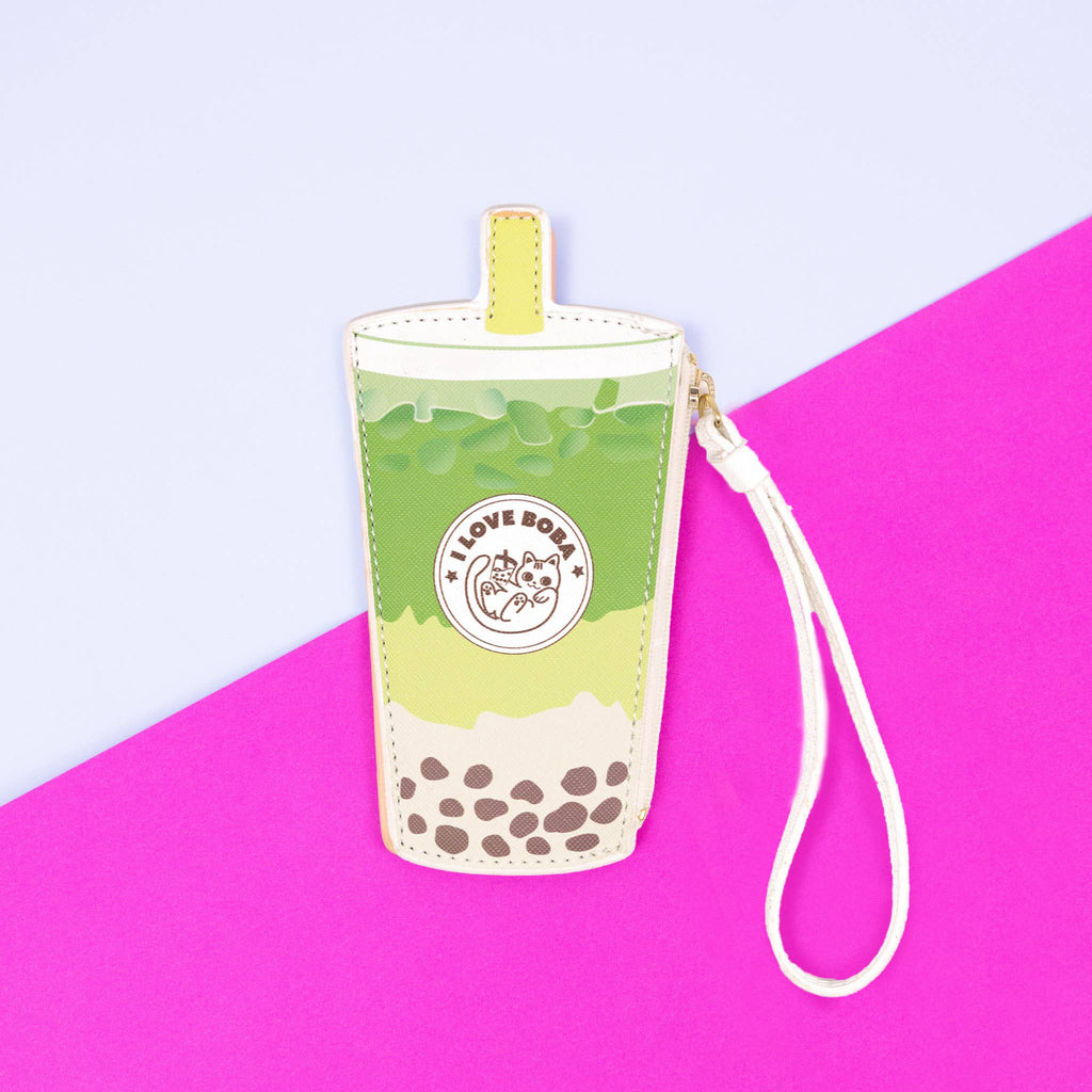 Boba tea-shaped pouch in green with a strap on a pink and purple background
