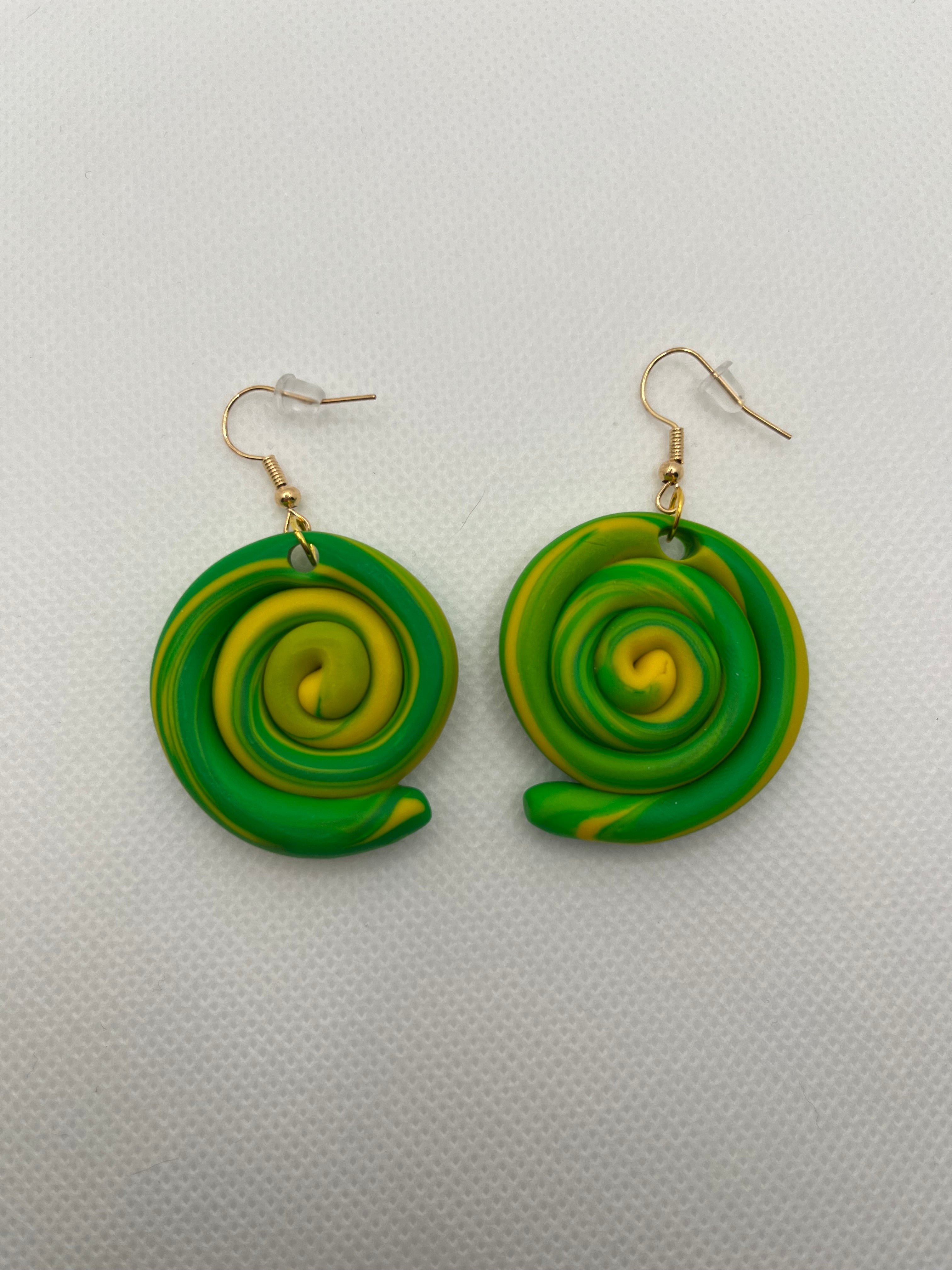 Green and yellow circle swirl earrings against a white background