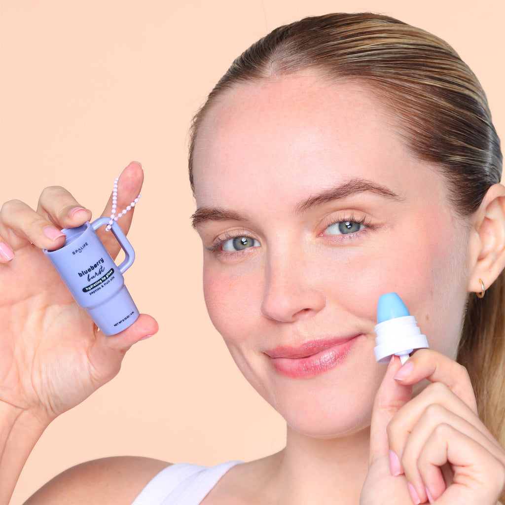 Woman holding a skincare product to her face on a beige background