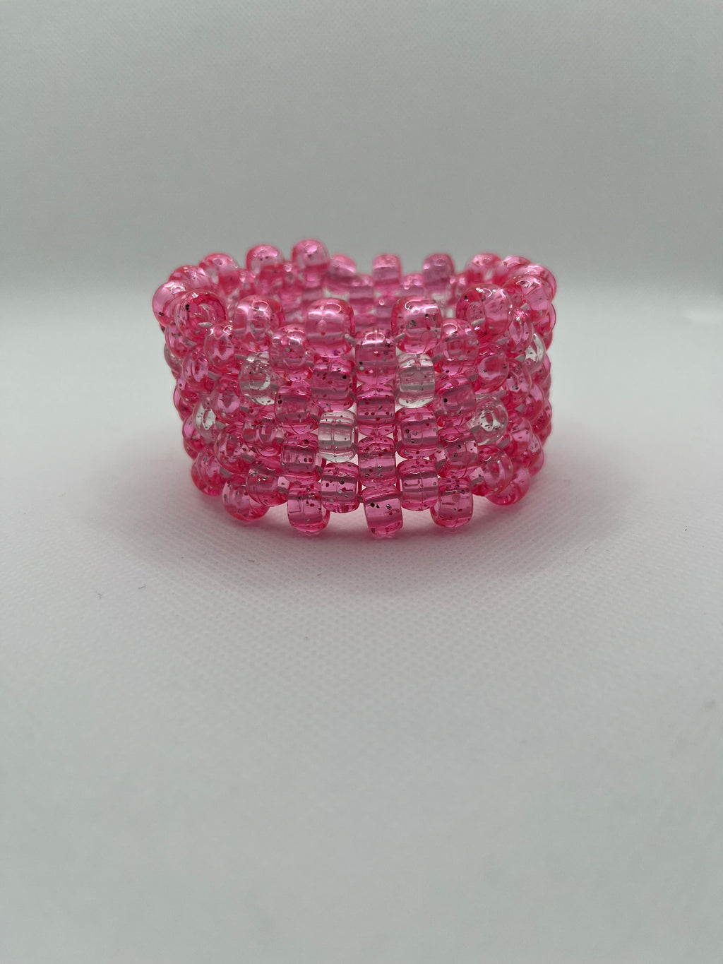 Pink glitter and clear beaded cuff bracelet on a white background.