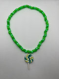 Green beaded necklace with green lollipop pendant on a white background