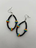 Black seed beads with rainbow beads throughout on earrings against a white background