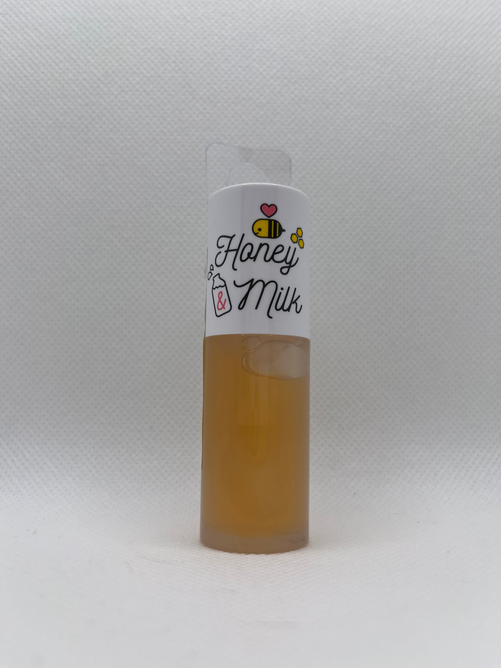 Small lip oil labeled 'Honey Milk' on a white background