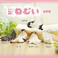 Cat-shaped figures on a blanket with Japanese text above