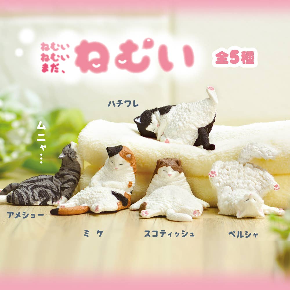 Cat-shaped figures on a blanket with Japanese text above