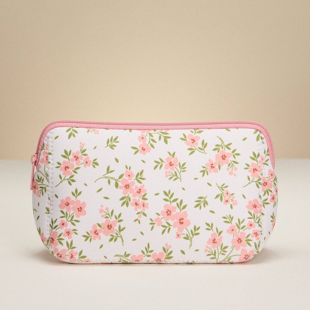 Floral patterned pouch with pink zipper on a beige background