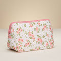 Floral-patterned pouch with pink zipper on a beige background