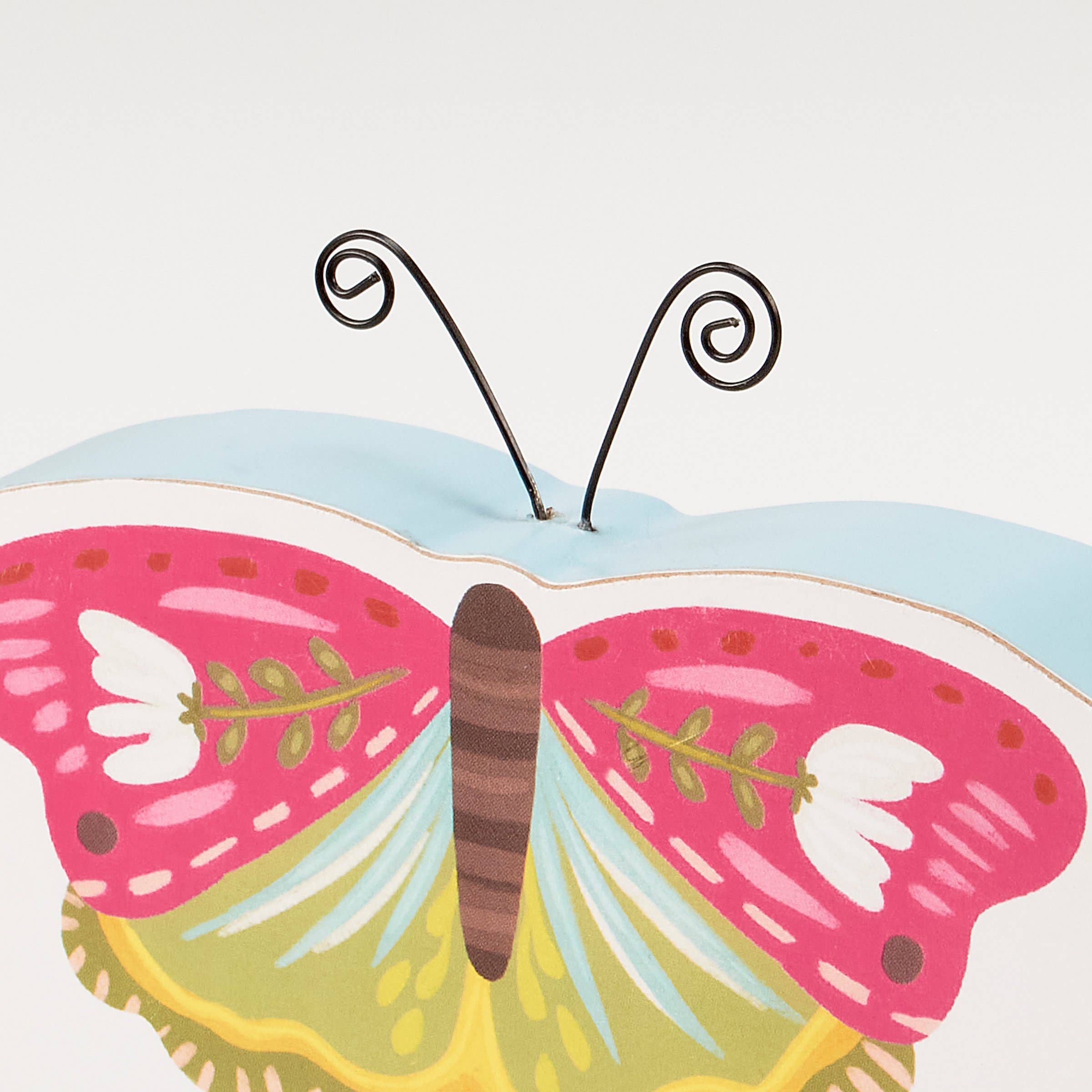 Colorful butterfly-shaped object with pink, yellow, and blue wings on a white background