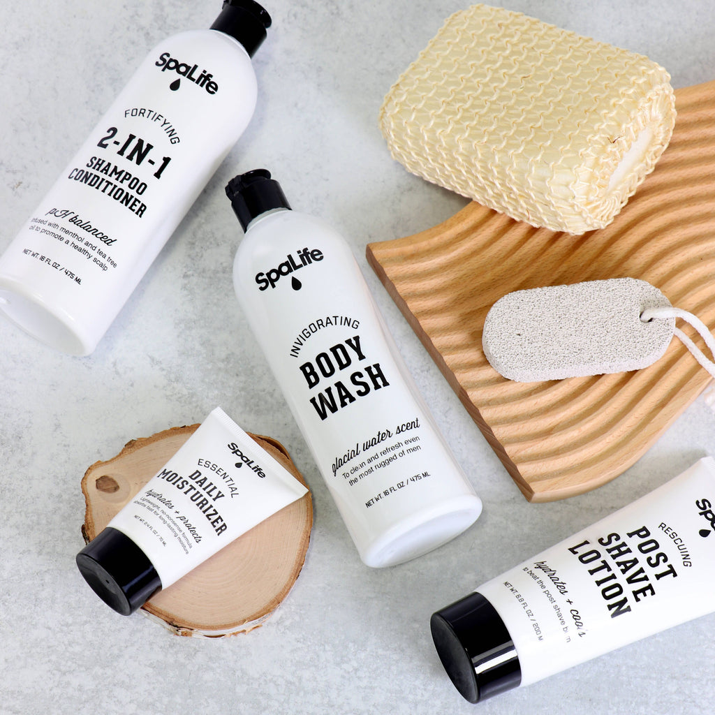 SpaLife skincare products including shampoo, body wash, moisturizer, and post-shave lotion on a textured surface.