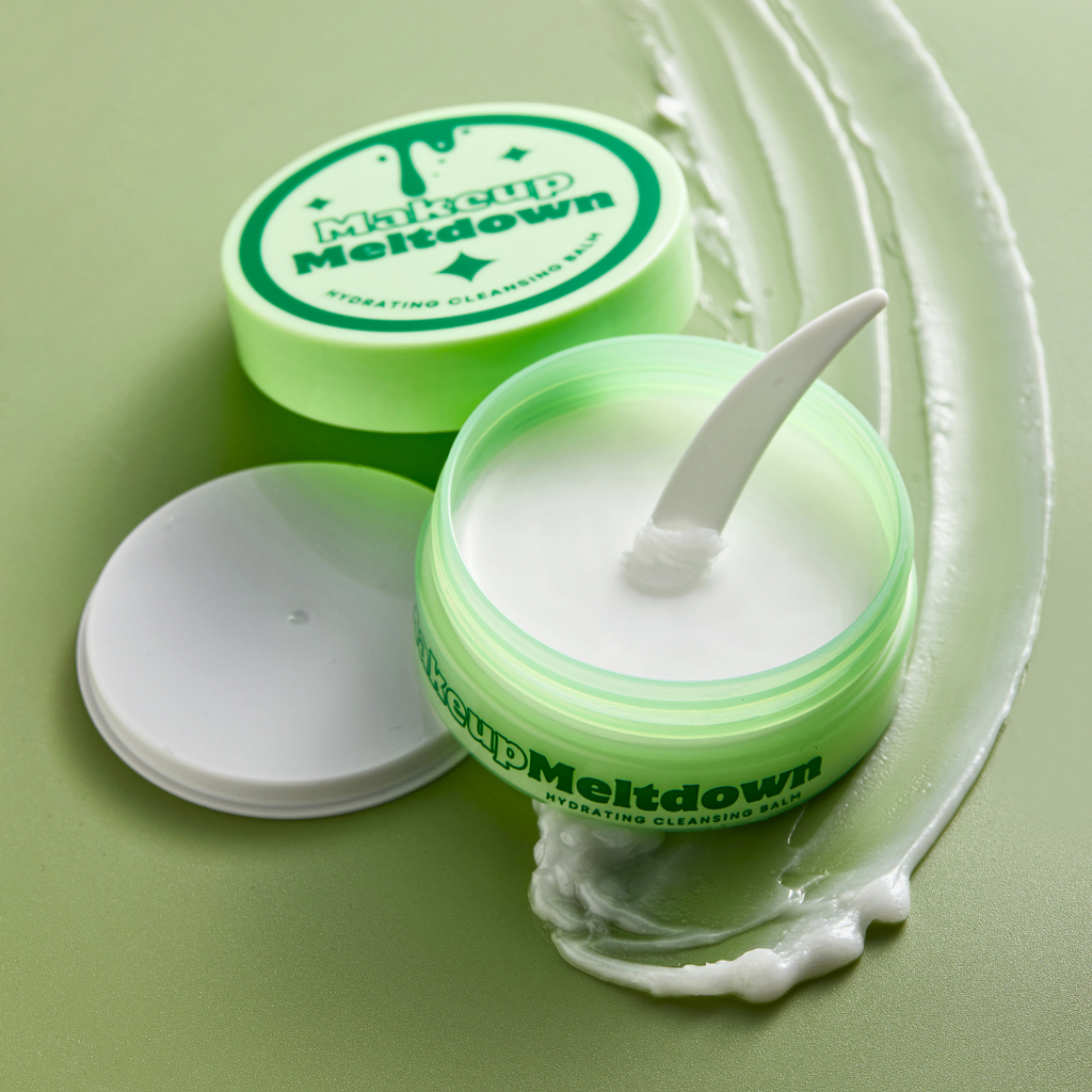 Makeup Meltdown cream jar with a white applicator on a green background