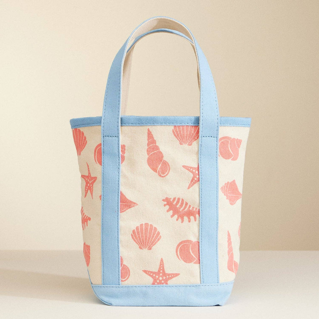 Tote bag with shell pattern and blue accents on a beige background