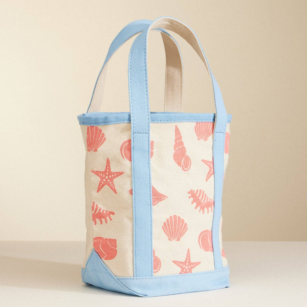 Tote bag with shell pattern and blue straps on a beige background